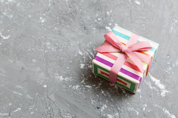Emballage cadeau de Noël ou autre boîte-cadeau faite main de vacances dans du papier de couleur avec ruban sur fond coloré Présenter la décoration de la boîte de cadeau sur la vue de dessus de table colorée avec espace de copie