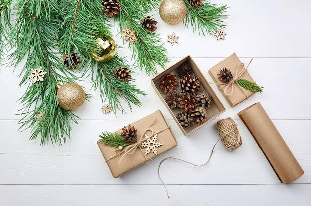 Emballage et décoration de cadeaux de Noël avec des branches d'arbres de pin festives sur table blanche