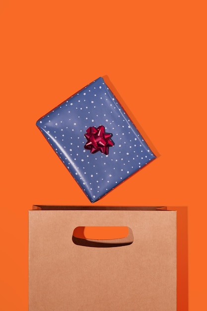 Emballage en papier brun avec boîte-cadeau sur fond orange Maquette