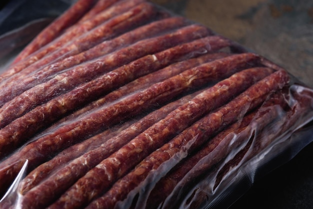 Emballage de saucisses fumées en gros plan dans un sac sous vide Produits de viande prêts à l'emploi pour supermarché