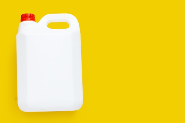 Photo emballage vierge gallon en plastique blanc sur fond jaune.