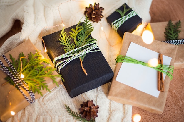 Photo emballer des coffrets cadeaux de noël avec des brindilles et du ruban