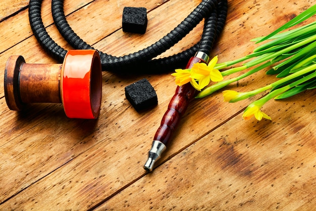 Embout de narguilé et gobelet de narguilé avec tabac de narcisse.Chicha sur tabac de fleur