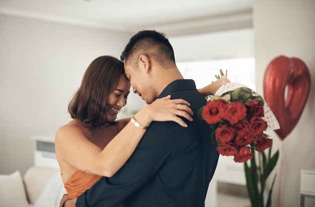 Embrasser chaque instant Photo d'un jeune homme surprenant sa femme avec des fleurs à la maison