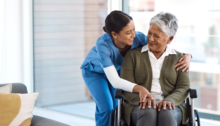 Photo embrasser une infirmière avec une femme âgée en fauteuil roulant et parler pour obtenir de l'aide sourire heureux et communication avec une infirmière tenant la main d'un patient âgé handicapé pour le soignant dans une maison de retraite