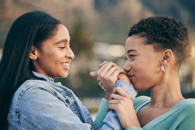 Embrasser à la main un couple gay ou des amies en plein air avec bonheur, amour et fierté des voyages d'été LGBTQ ou lesbiennes en vacances pour la liberté, rendez-vous romantique ou engagement envers un partenaire africain heureux