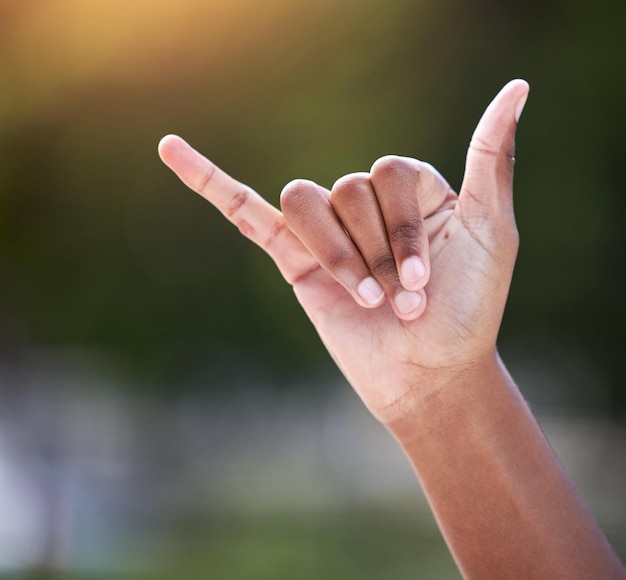 Embrassez le côté insouciant de la vie. Plan d'une personne méconnaissable montrant un signe shaka avec sa main à l'extérieur.