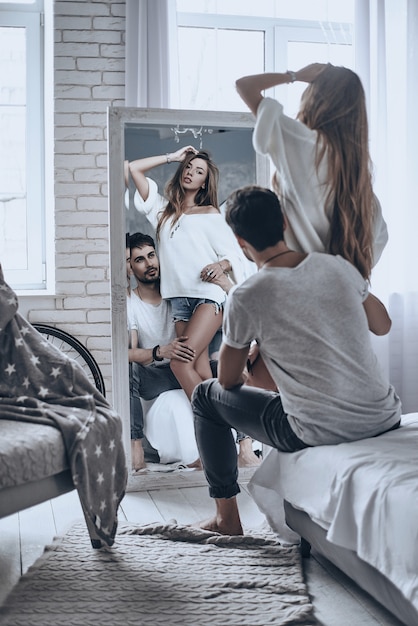 émerveillé par sa beauté. vue arrière de la belle femme regardant son reflet dans le miroir