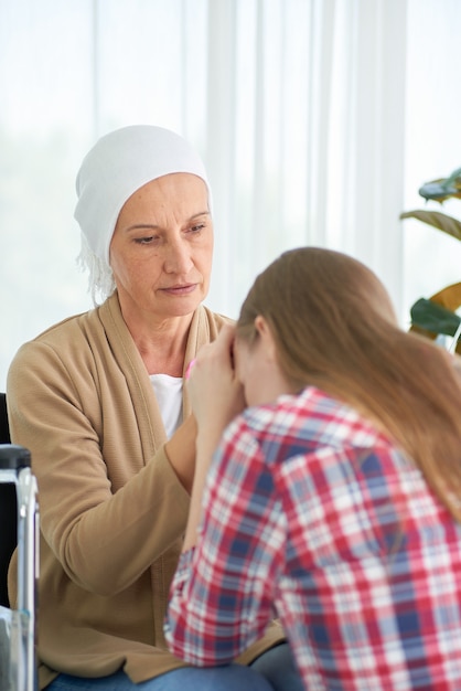 Photo Émotionnelle de la jeune fille blanche caucasienne avec espoir et sourire visitant et encourager à soutenir sa mère qui se bat avec la chambre d'hôpital du cancer du sein, campagne de ruban de sensibilisation au cancer du sein.