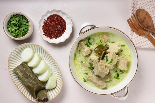 Photo empal gentong est une soupe de bœuf traditionnelle au lait de coco servie avec un gâteau de riz de cirebon