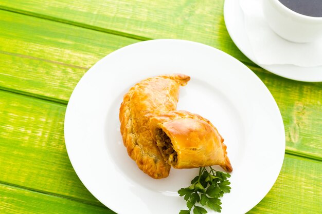 Empanada farcie de pain sur une assiette blanche.