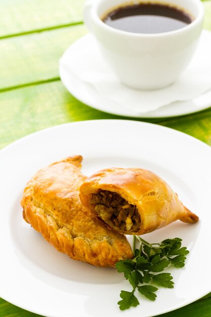 Empanada farcie de pain sur une assiette blanche.