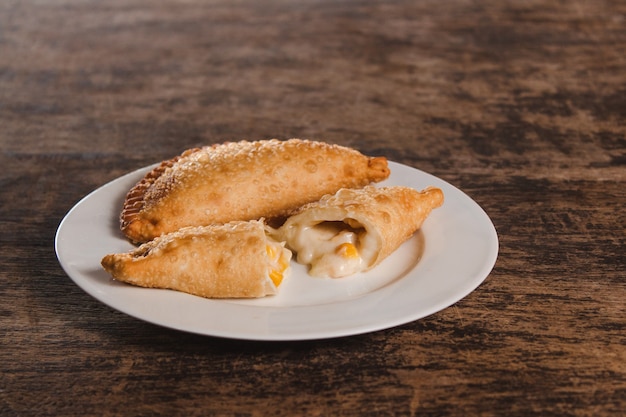 Empanadas au maïs et au fromage frits d'Amérique latine sur une table en bois