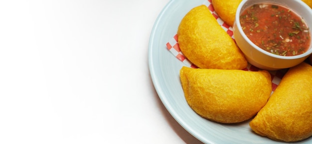 Empanadas colombiennes typiques avec sauce épicée sur fond blanc