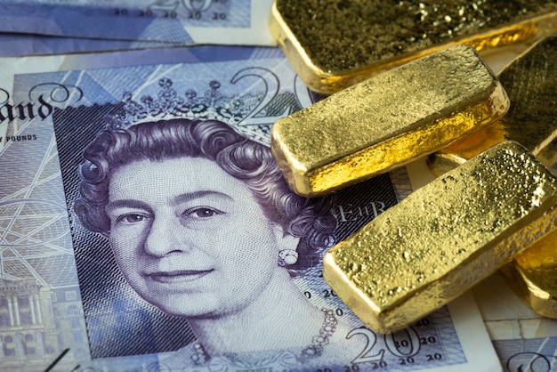 Photo empilé de lingot d'or sur le billet de banque, gbp ou livre avec lingot d'or