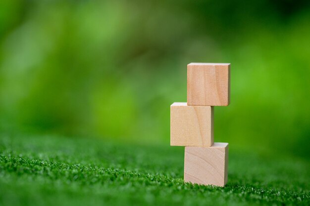 Empiler des cubes en bois vierges sur fond vert avec espace de copie pour le libellé d'entrée et l'icône infographique Bloc d'objet en bois marron vide pour l'icône de symbole mettre le concept d'entreprise de technologie zéro gravité