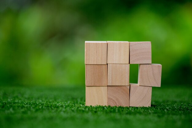 Empiler des cubes en bois vierges sur fond vert avec espace de copie pour le libellé d'entrée et l'icône infographique Bloc d'objet en bois marron vide pour l'icône de symbole mettre le concept d'entreprise de technologie zéro gravité