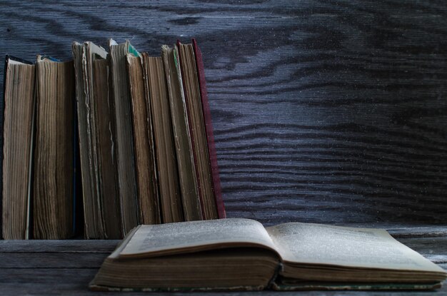 Empilez de vieux livres sur la texture en bois de table en bois sur le fond