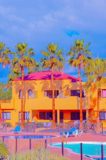 Emplacement minimaliste de la mode tropicale. Hôtel lumineux, piscine et Palm. Ciel bleu d'été. Les îles Canaries. Papier peint esthétique de voyage