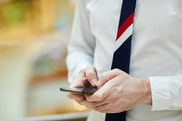 Employé de banque prenant note sur smartphone