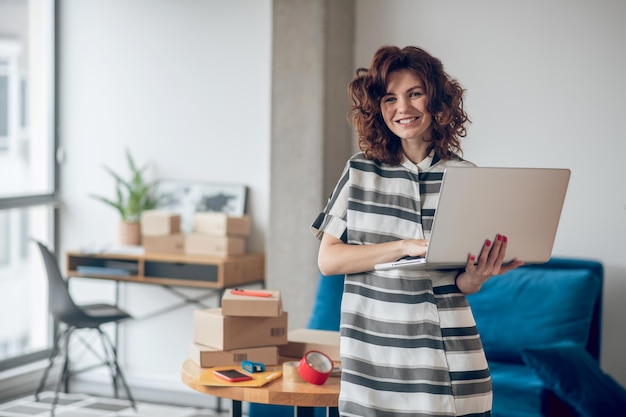 Employé de la boutique en ligne posant pour la caméra sur le lieu de travail