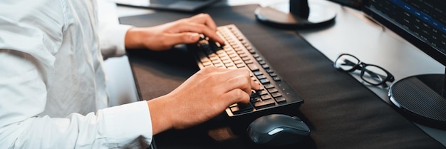 Employé de bureau assis sur un bureau d'espace de travail en tapant sur le clavier. Pionnier