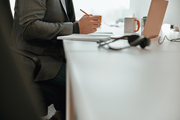 Un employé de bureau assis à son bureau et tenant un stylo
