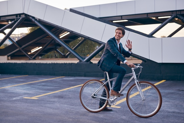 Employé de bureau branché sur un ami de salutation de vélo en ville