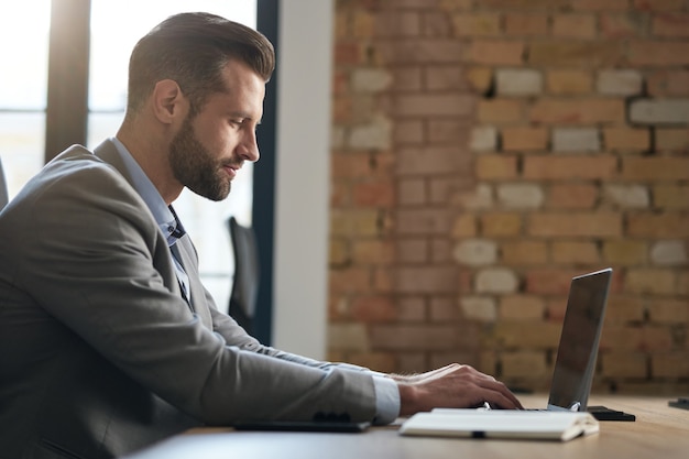 Employé de bureau en costume gris en tapant sur le clavier