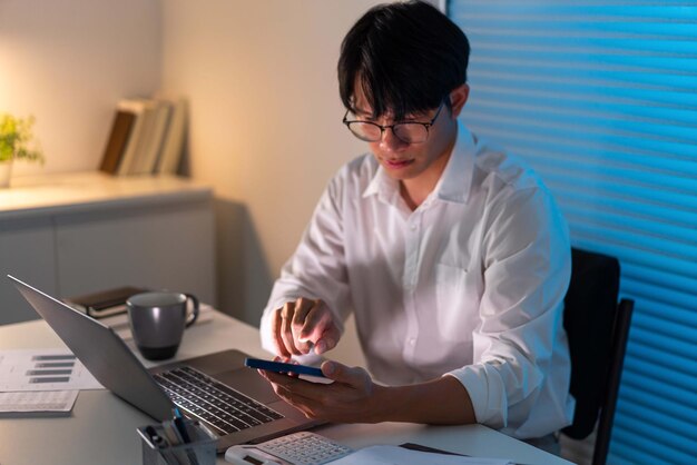 employé de bureau masculin qui porte un blazer blanc travaillant tard au bureau