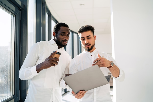 Employé de bureau montrant à son patron un rapport sur un ordinateur portable