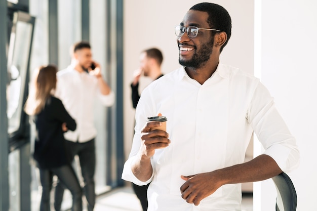 Employé de bureau noir buvant du café en pause