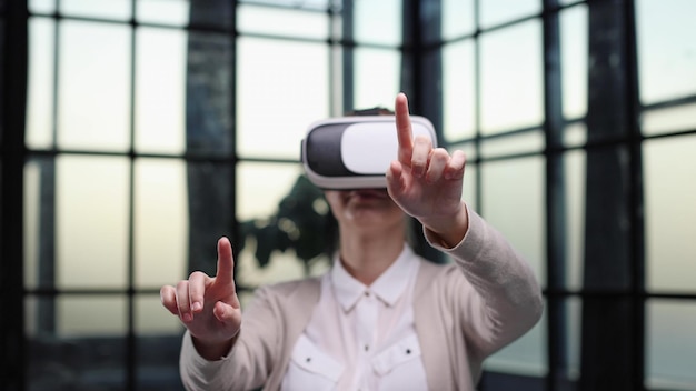 Employé de bureau s'amusant au travail en regardant une vidéo 3D dans des lunettes de réalité virtuelle femme touchant quelque chose en réalité virtuelle
