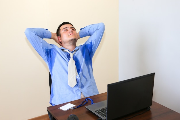 Employé de bureau en sueur. Chemise mouillée. Mauvaises conditions de travail. Gestionnaire malheureux. La chaleur de l'été. Pas de climatisation dans l'immeuble.