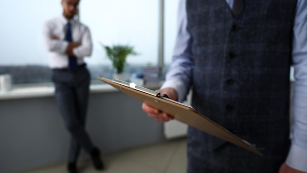 Un employé de bureau vêtu d'un costume et d'une cravate avec du papier coupé au bloc-notes