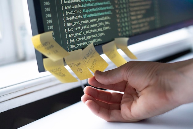 Photo un employé du bureau fixe l'autocollant de note papier à l'écran de l'ordinateur