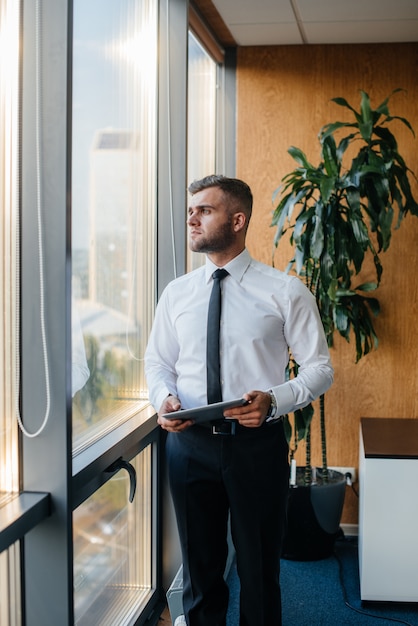 Un employé du bureau se tient près de la fenêtre