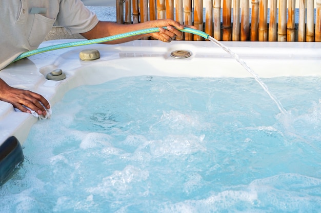 Photo employé du personnel de l'hôtel africain nettoyant la piscine