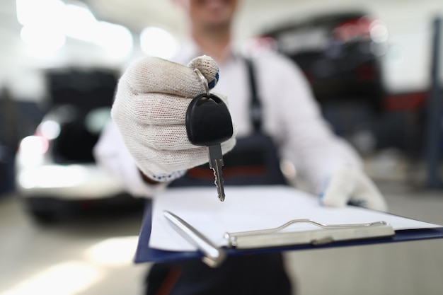 L'employé du service de voiture tient les clés en main et le presse-papiers