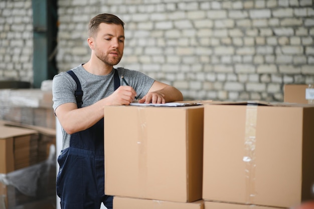 Employé d'entrepôt transportant un carton pour livraison au stock de production