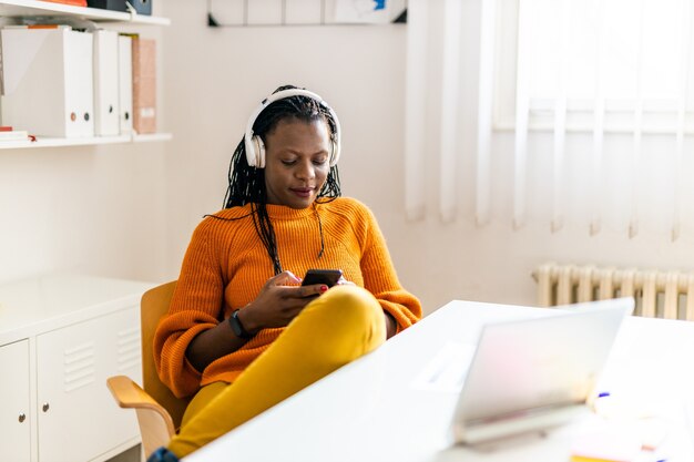 Employé de l'entreprise commerciale se reposant au bureau avec des écouteurs