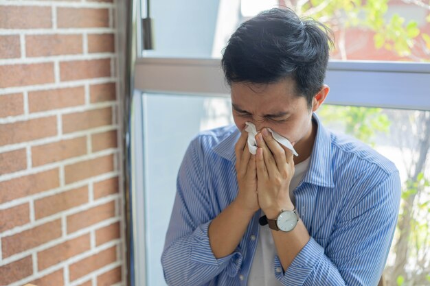 Un employé a froncé les sourcils et éternue tout en travaillant à la maison pour le concept de coronavirus et de temps de quarantaine