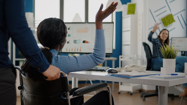 Employé d'homme aidant son collègue africain invalide à venir sur le lieu de travail