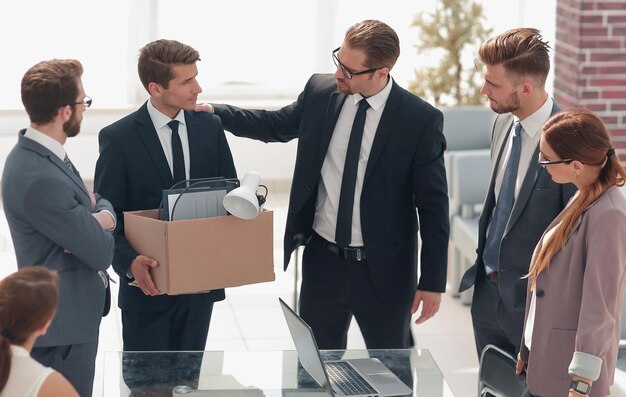 Employé licencié avec des choses personnelles disant au revoir à ses collègues