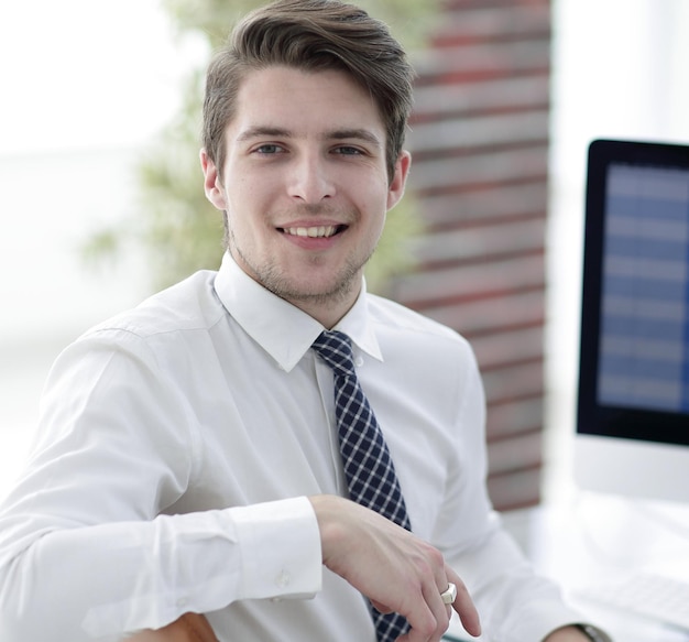 Employé prospère assis devant une photo d'écran d'ordinateur avec espace de copie