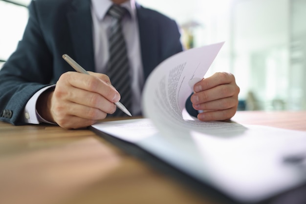 Un employé retourne la page de la signature du contrat après avoir lu