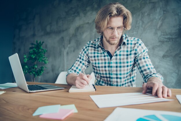 employé sérieux travaillant au bureau avec ordinateur portable