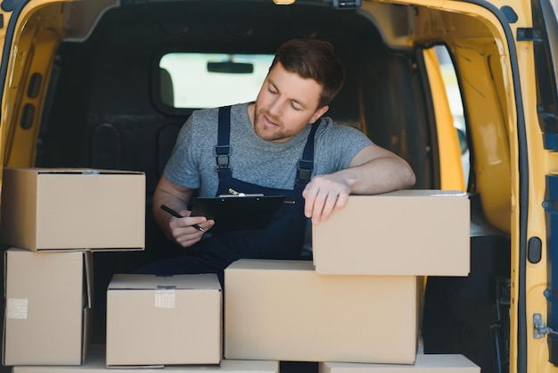 Employé de service de livraison Portrait d'un homme travaillant dans un service de livraison Portrait de coursier avec boîte Courrier à côté d'une fourgonnette Carrière de service de livraison