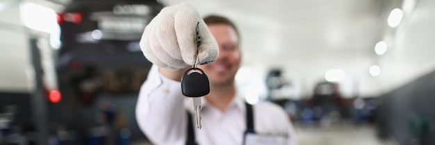 Un employé de service masculin donne les clés d'une automobile fixe au propriétaire
