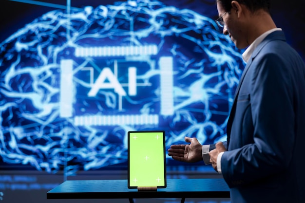 Employé d'une start-up regardant une tablette à écran vert utilisant un logiciel d'intelligence artificielle